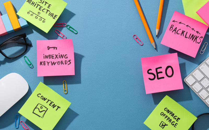 Colorful sticky notes with SEO-related terms like "Backlinks," "Indexing," and "Content" arranged on a blue desk